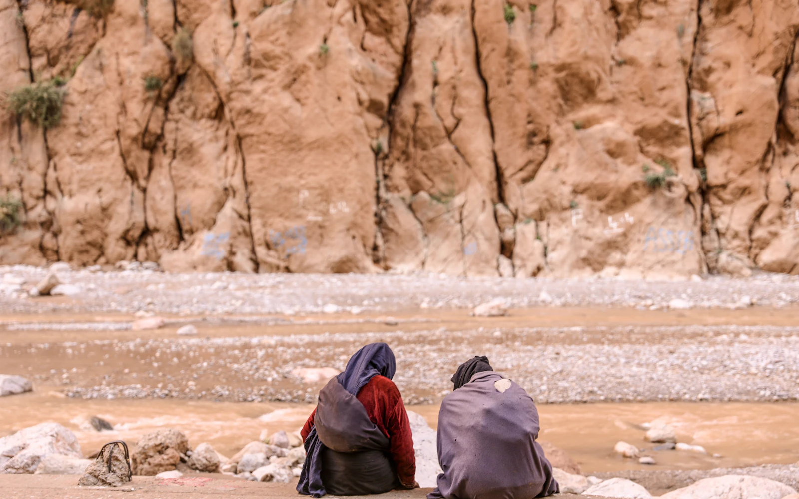 Viajeros en un cañón de roca roja, garganta del Todra