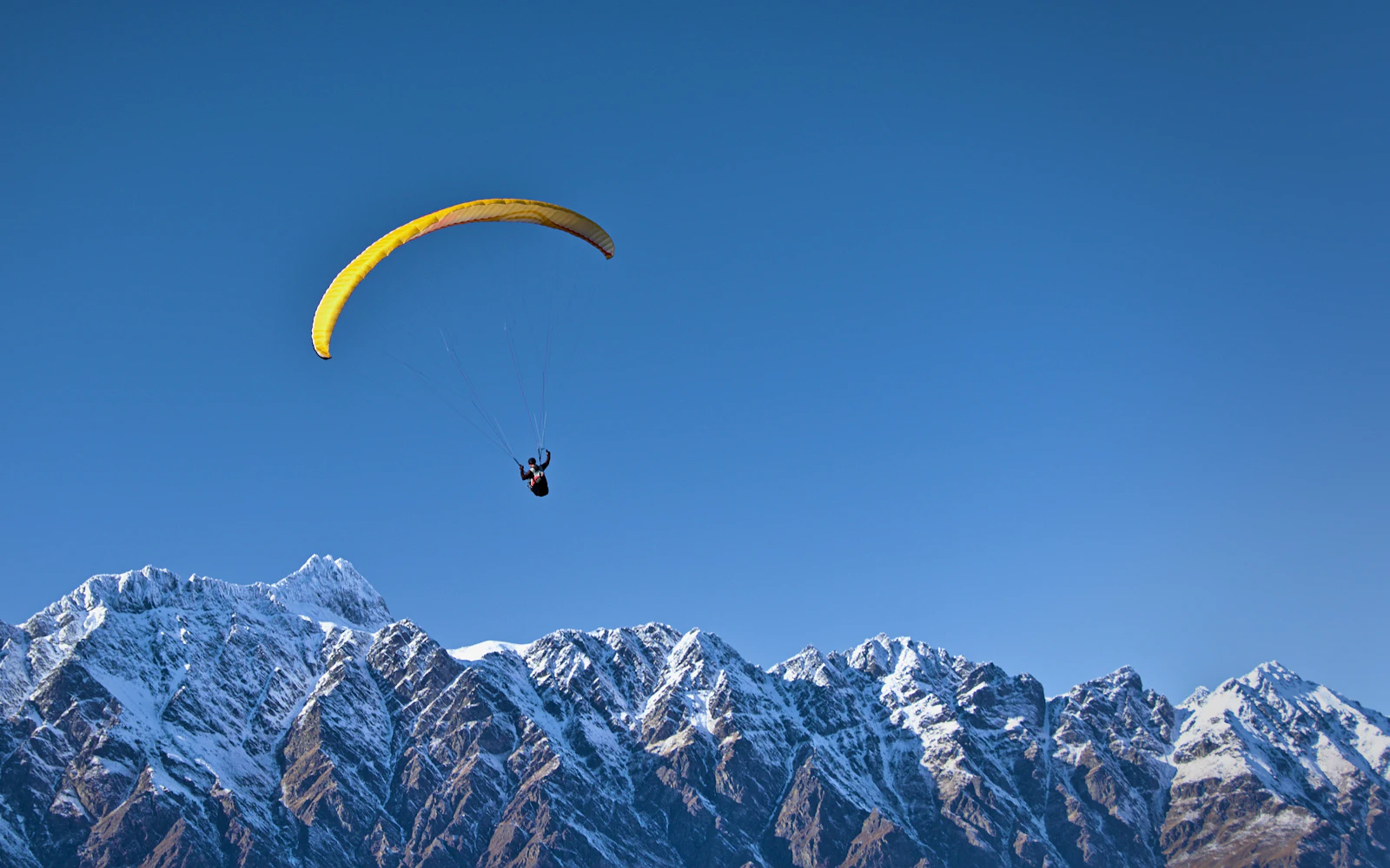 Parapente au-dessus des montagnes enneigées